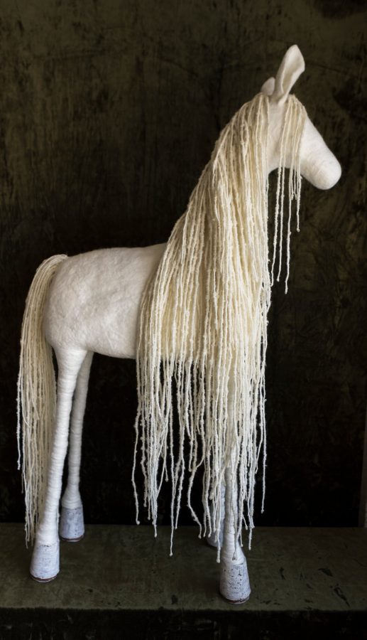 A white horse with a long mane of thread